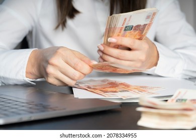 Hands of a financial worker in a white shirt counting money bills. A large bundle of money close-up.