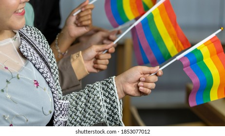 Hands Of Five Business Women From Different Ethnic Races And Cultures Express Support For LGBT With Flags In An Office