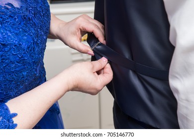 Hands fixing the groom vest