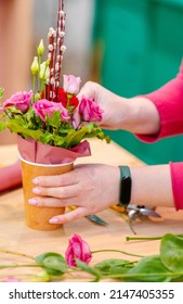 Hands of a florist creating a flower arrangement for Easter close-up 