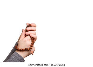 Hands Folded In Prayer With A Christian Rosary With A Cross Isolated On A White Background. 