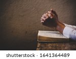 Hands folded in prayer on a Holy Bible in church concept for faith, spirituality and religion, woman praying on holy bible in the morning. woman hand with Bible praying.