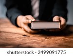 Hands folded in prayer on a Holy Bible in church concept for faith, spirituality and religion, woman praying on holy bible in the morning. woman hand with Bible praying.