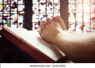 Hands Folded In Prayer On A Holy Bible In Church Concept For Faith, Spirituality And Religion