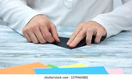 Hands Folding Black Paper Sheet. Man Making Origami Close Up. How To Fold Origami Swan Instructions.