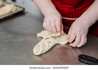 Hands folding dough into a braided pastry shape, ready for baking perfection - Powered by Shutterstock