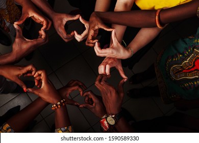 Hands in the form of heart of happy group of multinational African, latin american and european people which stay together in circle