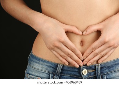 Hands Forming Heart On Female Belly Button. Healthy Stomach Health Concept, Or Early Pregnancy Concept