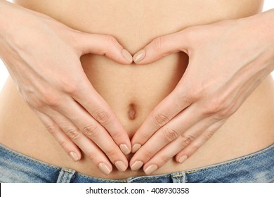 Hands Forming Heart On Female Belly Button. Healthy Stomach Health Concept, Or Early Pregnancy Concept