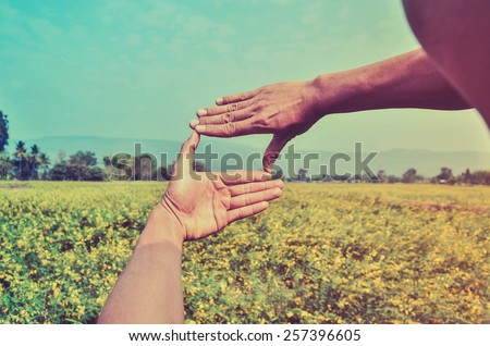 Hands framing distant