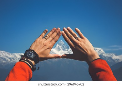 Mãos emoldurando o pico da montanha nevada. Monte. Machapuchare (6.993 m) no centro (Nepal, Himalaia).