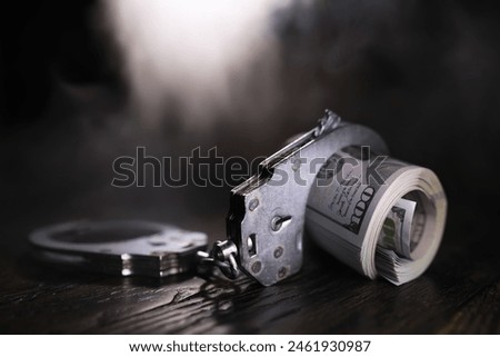 Hands of a fraudster with handcuffs on a background of us dollars and credit cards. Fraud, cyber crime concept. credit card fraud. Arrest of an entrepreneur in the workplace.