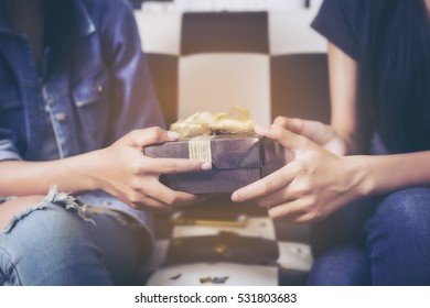 Hands Of Friend Giving A Christmas Gift To Friend.