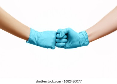 Hände von Freunden in medizinischen Handschuhen, die sich gegenseitig mit einer ersten Klappe einzeln auf weißem Hintergrund begrüßen.