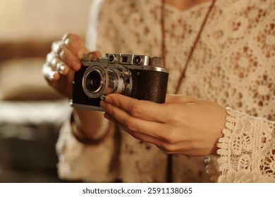 Hands gently holding vintage camera while intricately adjusting settings, framed against a soft, blurred background in indoor setting highlighting details of camera body and hands - Powered by Shutterstock - Get 15% off with code: PIKWIZARD15