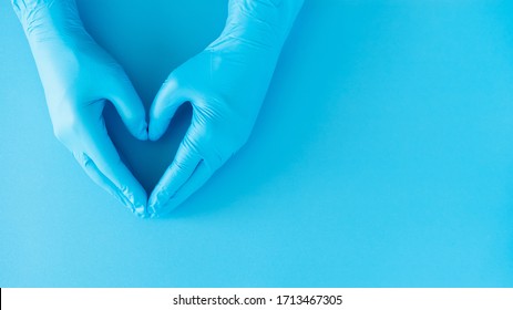 Hands Gesture Of Doctor Wearing Blue Gloves On Blue Background, Heart Shape Sign For Love