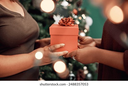 Hands, gift and Christmas party for celebration, holiday and festive as happy friends in home. Female people, together and presents with season, sharing or solidarity for relationship in December - Powered by Shutterstock