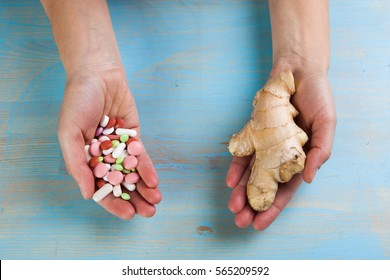 Hands with ginger and different pills on a blue background.
Choose between the traditional and folk medicine. The concept of health. - Powered by Shutterstock