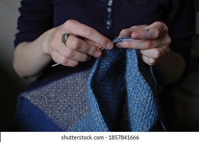 Hands Of A Girl In Blue Clothes Crochet A Blue Sweater Close-up