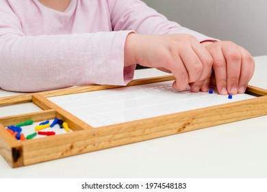 The Hands Of A Girl In Close-up. Picking Up The Mosaic. Hands Of A Child Close-up. Braille Board For Learning Alphabet.