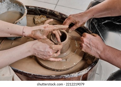 Hands Of Girl Craftswoman, Teaching Pottery Craft, Sculpting Clay Vase On Potter's Wheel, . Hands Of Senior Woman At Pottery Training Lesson. Hobby Concept