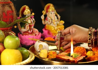 Hands Of Girl Holding Ghanti Bell. Clay Diya Deep Dia Lamp Illuminated In Pooja Thali For Aarti Of Maa Lakshmi  Bhagwan Ganesh Deva. Diwali Puja , New Year, Deepawali Or Shubh Deepavali Theme