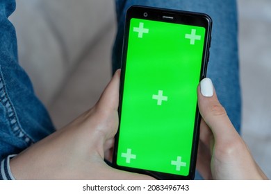 Hands Of A Girl Using A Mobile Phone With A Green Chroma Screen . Remote Access Concept.