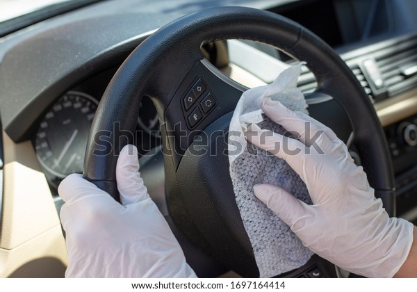Hands with glove\
wiping car steering wheel