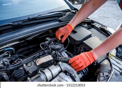 Hands In Gloves With Car Engine Close Up