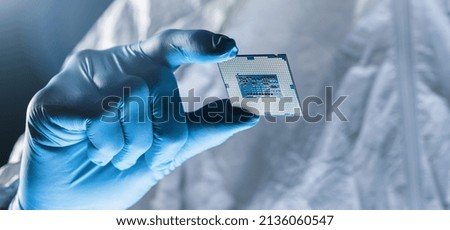 Hands in gloves hold Microchip testing microelectronics at a Ultra Modern Electronic Manufacturing Factory