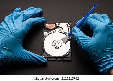 Hands in gloves with a microfiber swab are cleaned the computer hard drive. Data cleaning, HDD recovery.