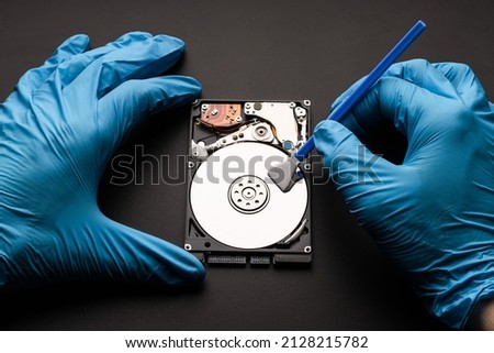 Hands in gloves with a microfiber swab are cleaned the computer hard drive. Data cleaning, HDD recovery.
