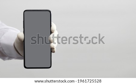 hands with gloves and phone with gray screen, white background