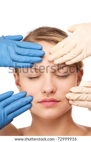 hands in gloves touching the face of a young woman