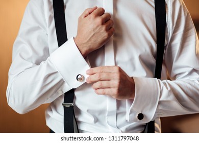 Hand's groom wears a metallic silver cufflinks stud. stylish wedding accessories. Wedding morning - Powered by Shutterstock