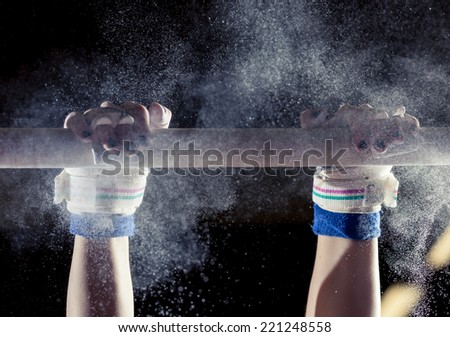 hands of gymnast with chalk on uneven bars 