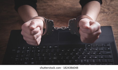 Hands In Handcuffs On Laptop Keyboard. Cyber Crime 