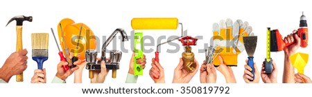 Hands of handyman with tools. House renovation and construction.
