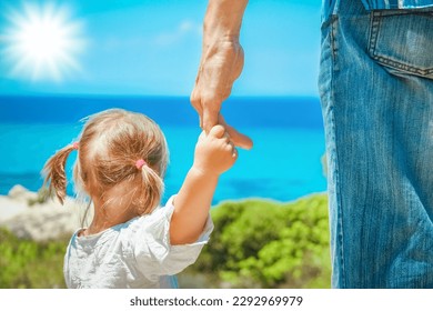 hands of happy parent and child at sea greece background - Powered by Shutterstock