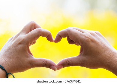 Hands As A Hart Shape With Yellow Background