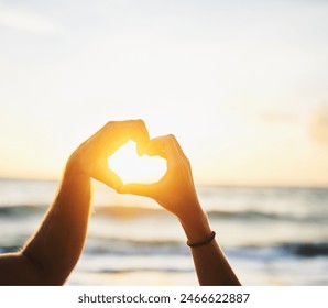 Hands, heart and couple on beach with sunset for love with vacation or holiday with lens flare on horizon. Outdoor, relationship and travel in nature for fun on weekend with date, together and symbol - Powered by Shutterstock