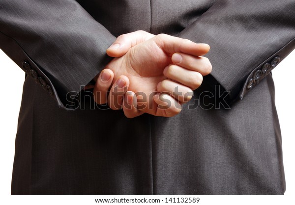 hands held behind\
the back of a suited man