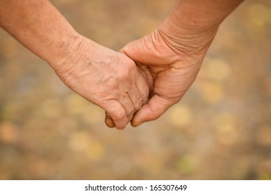 Hands held together on a natural yellow background