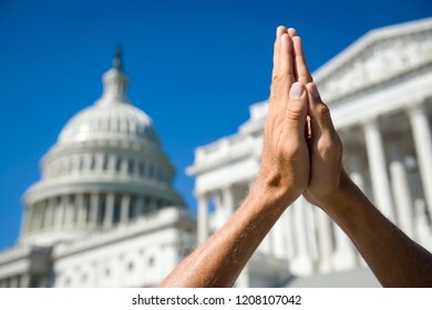 Hands Held Together In Prayer In Front On Capitol Building In Washington DC, USA