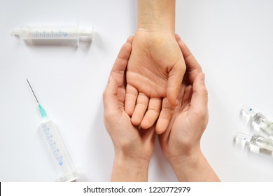 Hands Helping Drug Addict Teenage On White Background With Syringe And Ampoules. International Day Against Drugs Abuse. Stop Drug Addiction By Rehabilitation In Rehab Center. Trust And Ethics Concept