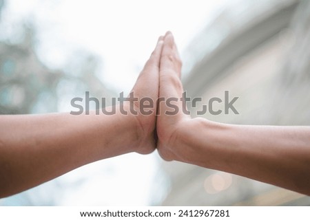 hands hi5 while standing outside of the office at City, Business Colleagues hitting hands