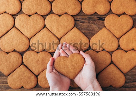 Hands hold cookies in form of heart 