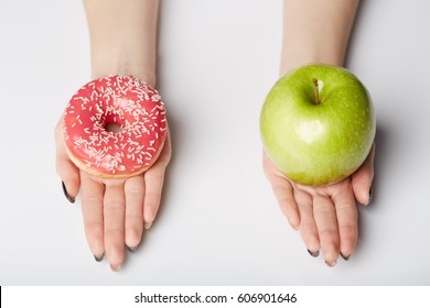 hands hold donut and apple on white background - Powered by Shutterstock