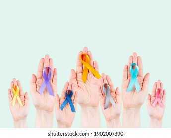 Hands hold multicolored ribbons, symbol of the fight against cancer. World cancer day - Powered by Shutterstock