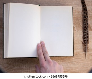 
Hands Hold The Open Closed Book Cover (diary) And A Pen. Wooden Table Background